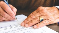 man signing will